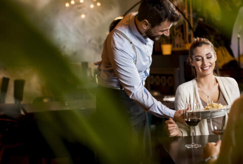 il cameriere serve il piatto a un cliente nel ristorante